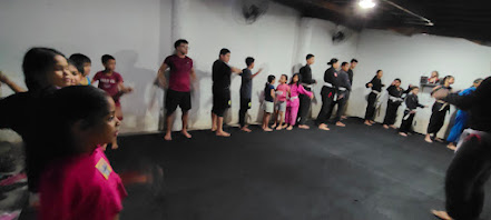 Alunos reunidos no tatame durante treino do projeto