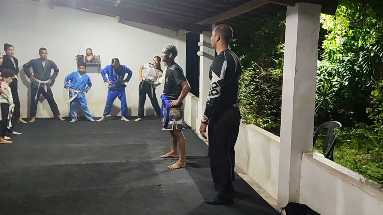 Instrutores e alunos reunidos durante atividade no tatame